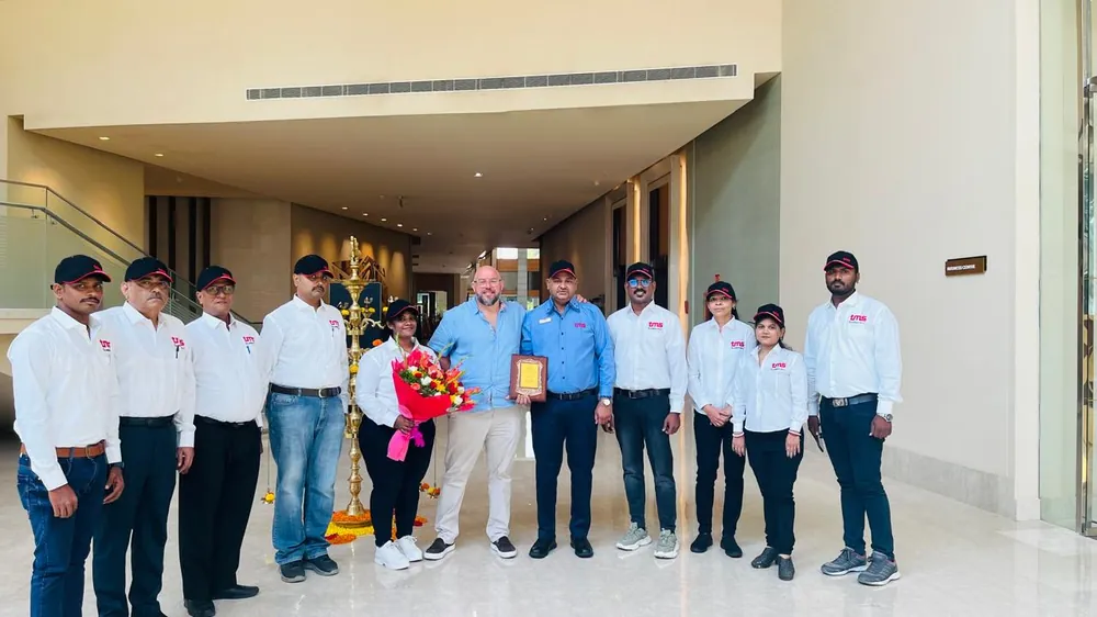 The TMS India team at the opening of the office, around a traditional brass lamp