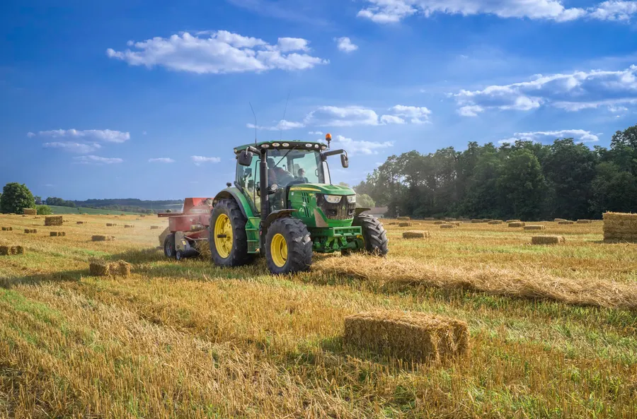 Tractor baling straw in a field